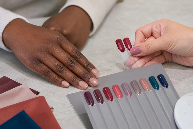 Due campioni berry accostati a una mano, con altri smalti applicati su tip.