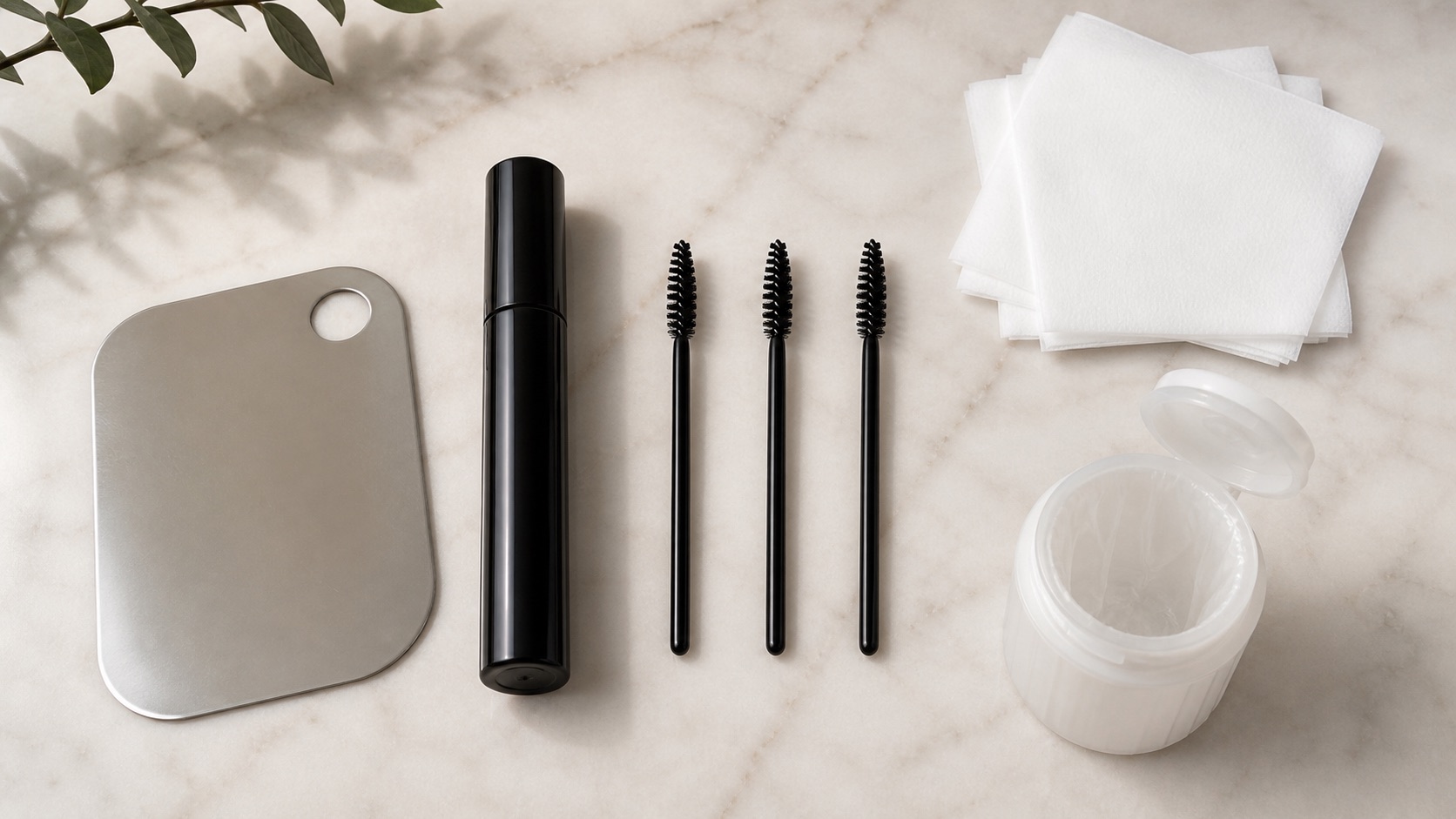 Postazione make-up pulita con tre scovolini mascara monouso, tubo chiuso, tavolozza, veline e contenitore di scarto