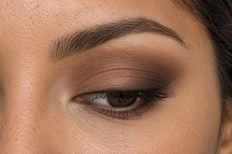 Smokey marrone ravvicinato con scuro alle ciglia, tono medio sulla palpebra e bordo sfumato
